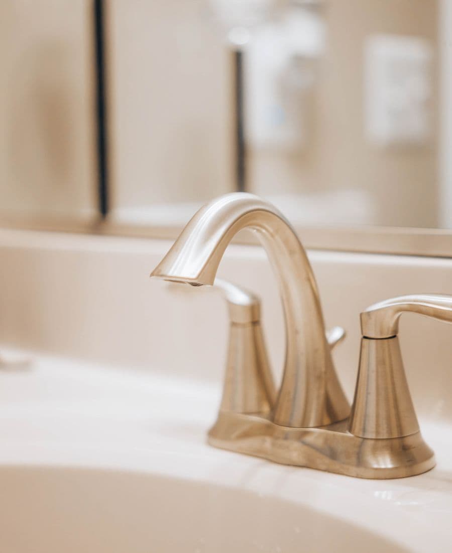 Modern stainless-steel mixer tap on a fitted bathroom basin