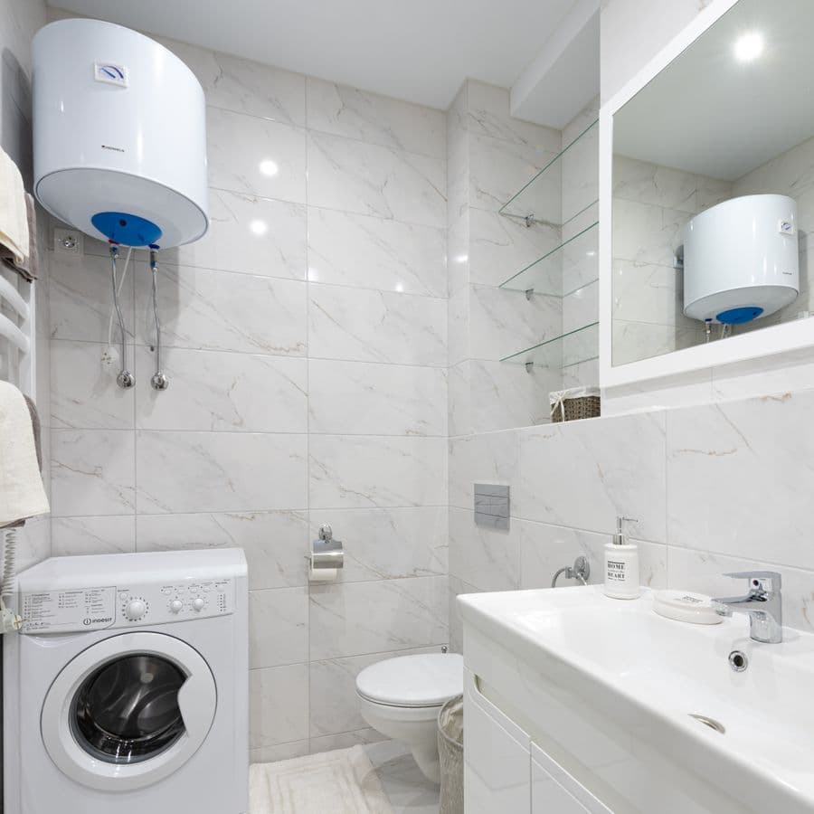 Finished minimalist bathroom installation with a wall-mounted boiler and sink