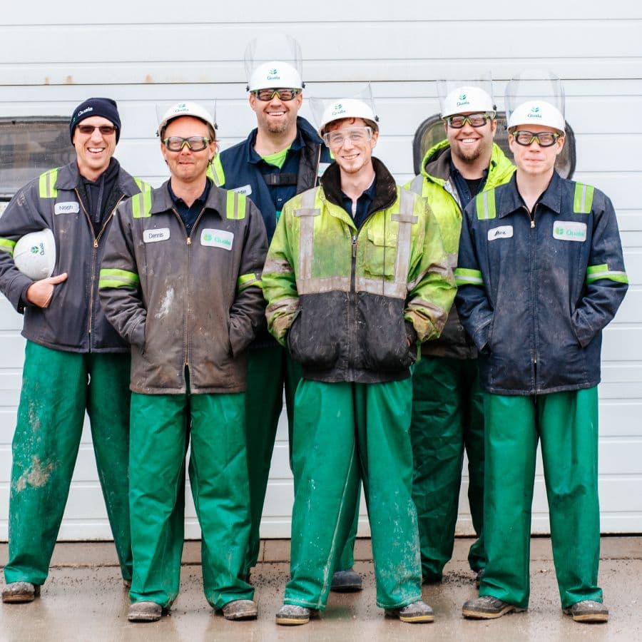 Group of workers in matching uniforms and safety gear standing together