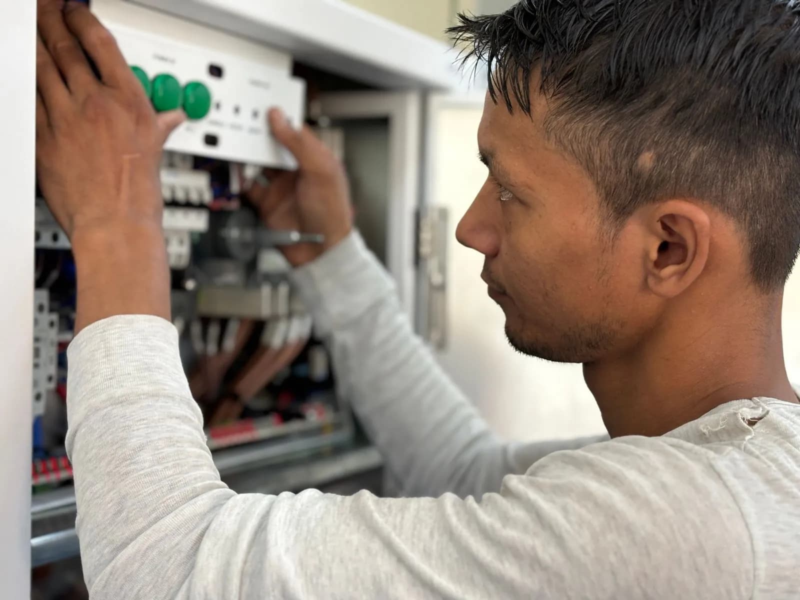 Electrician fitting a module into a distribution board