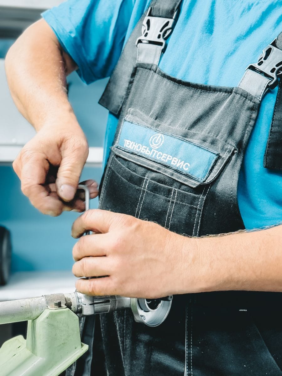 Plumber tightening a pipe fitting — the kind of real job photo a plumber website should show