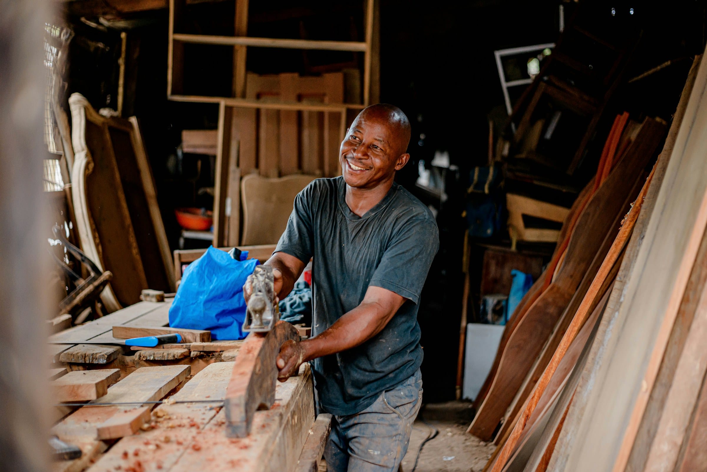 Carpenter smiling while working timber in his workshop