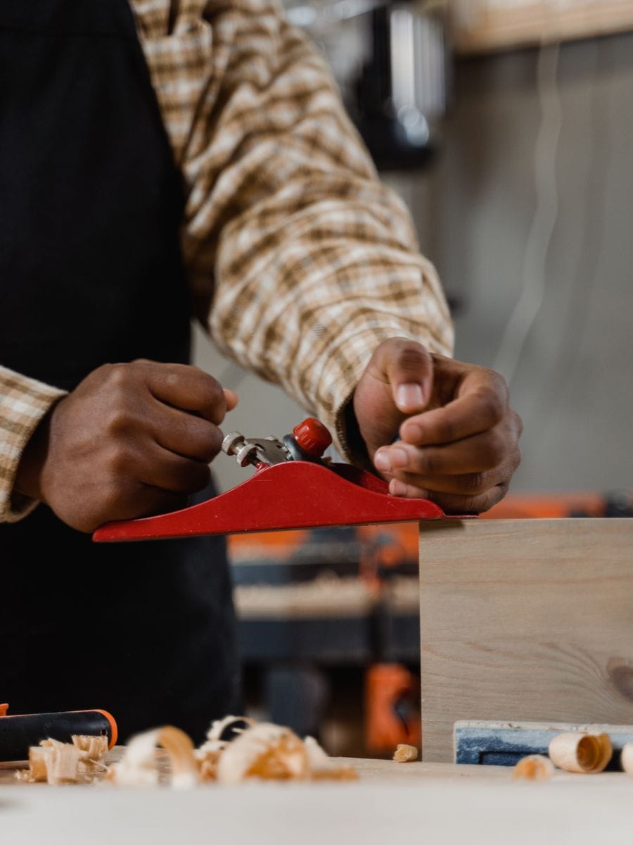 Carpenter measuring and cutting timber in a workshop, photographed for a carpenter website